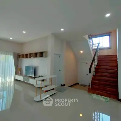 Spacious modern living room with elegant staircase and natural light