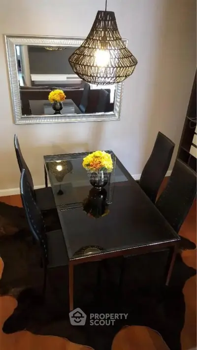 Elegant dining room with modern black table, stylish chairs, and chic pendant light.