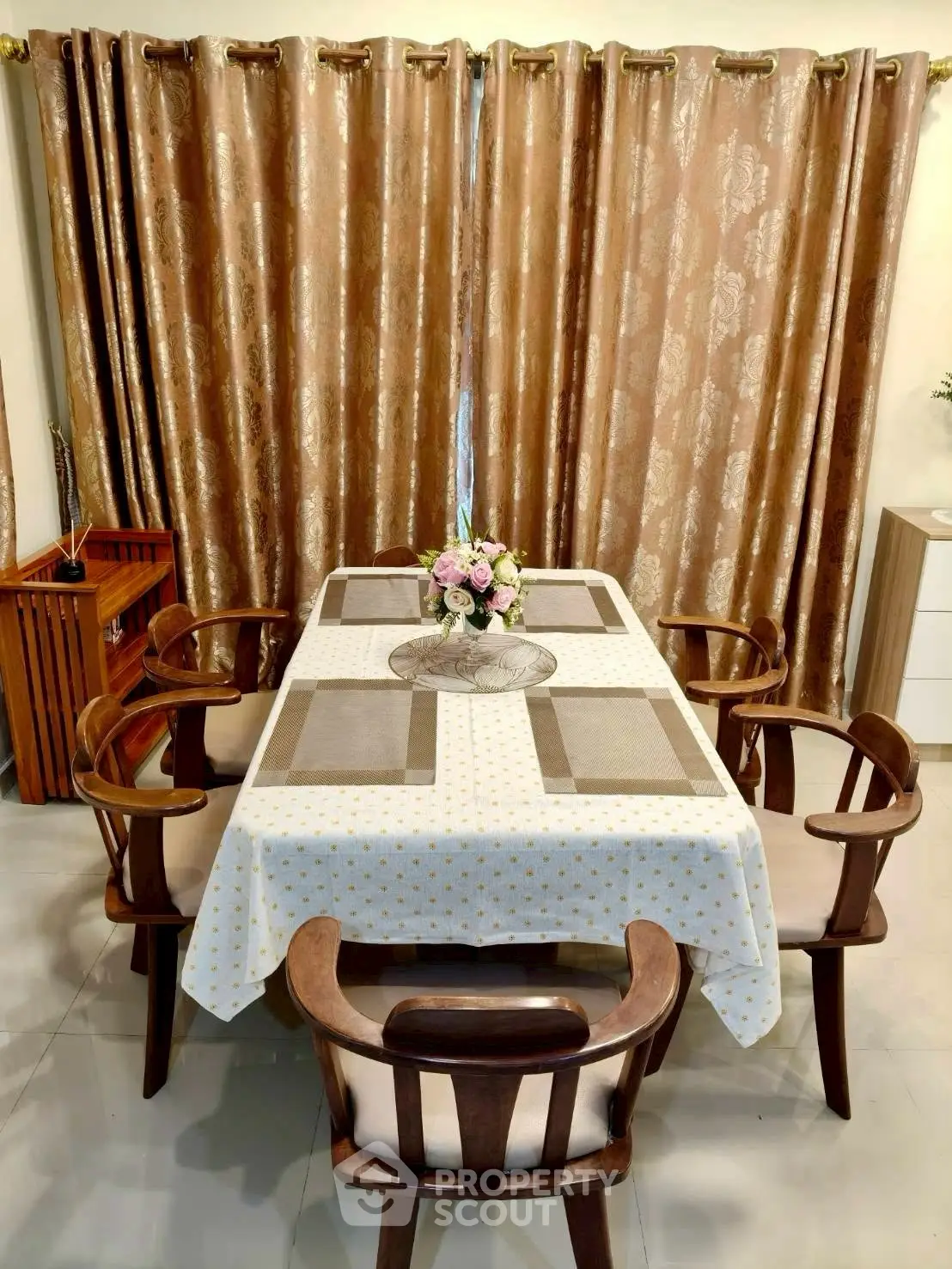 Elegant dining room with stylish wooden chairs and floral centerpiece, perfect for family gatherings.