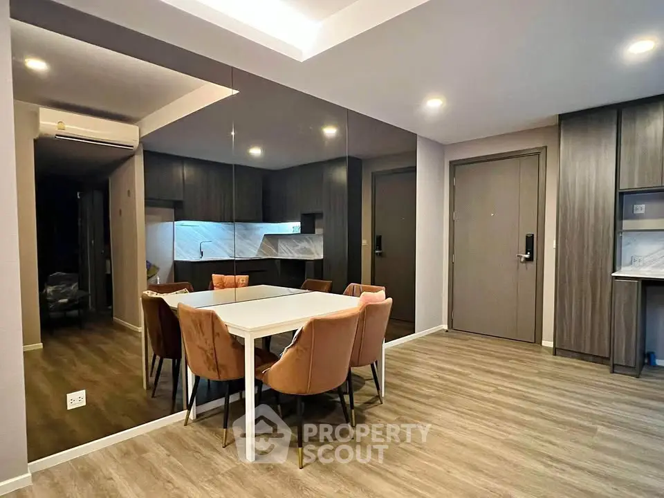 Modern dining area with elegant chairs and mirrored wall in a stylish apartment