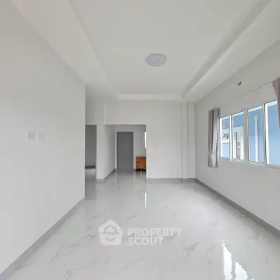 Spacious modern living room with large windows and sleek marble flooring