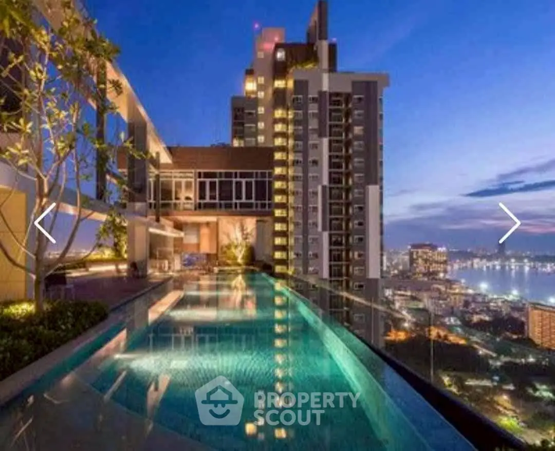 Luxurious rooftop pool with stunning city skyline view at dusk.