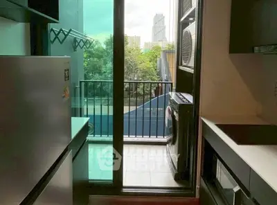 Modern kitchen with balcony view and laundry area in urban apartment.