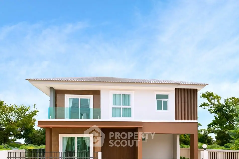 Modern two-story house with balcony and lush surroundings.