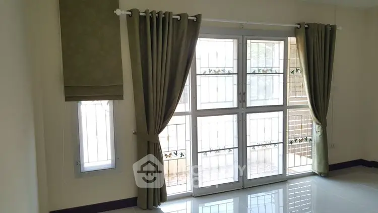 Bright room with large windows and elegant curtains, perfect for natural light lovers.