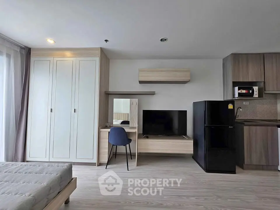 Modern studio apartment with sleek furniture and open kitchen layout