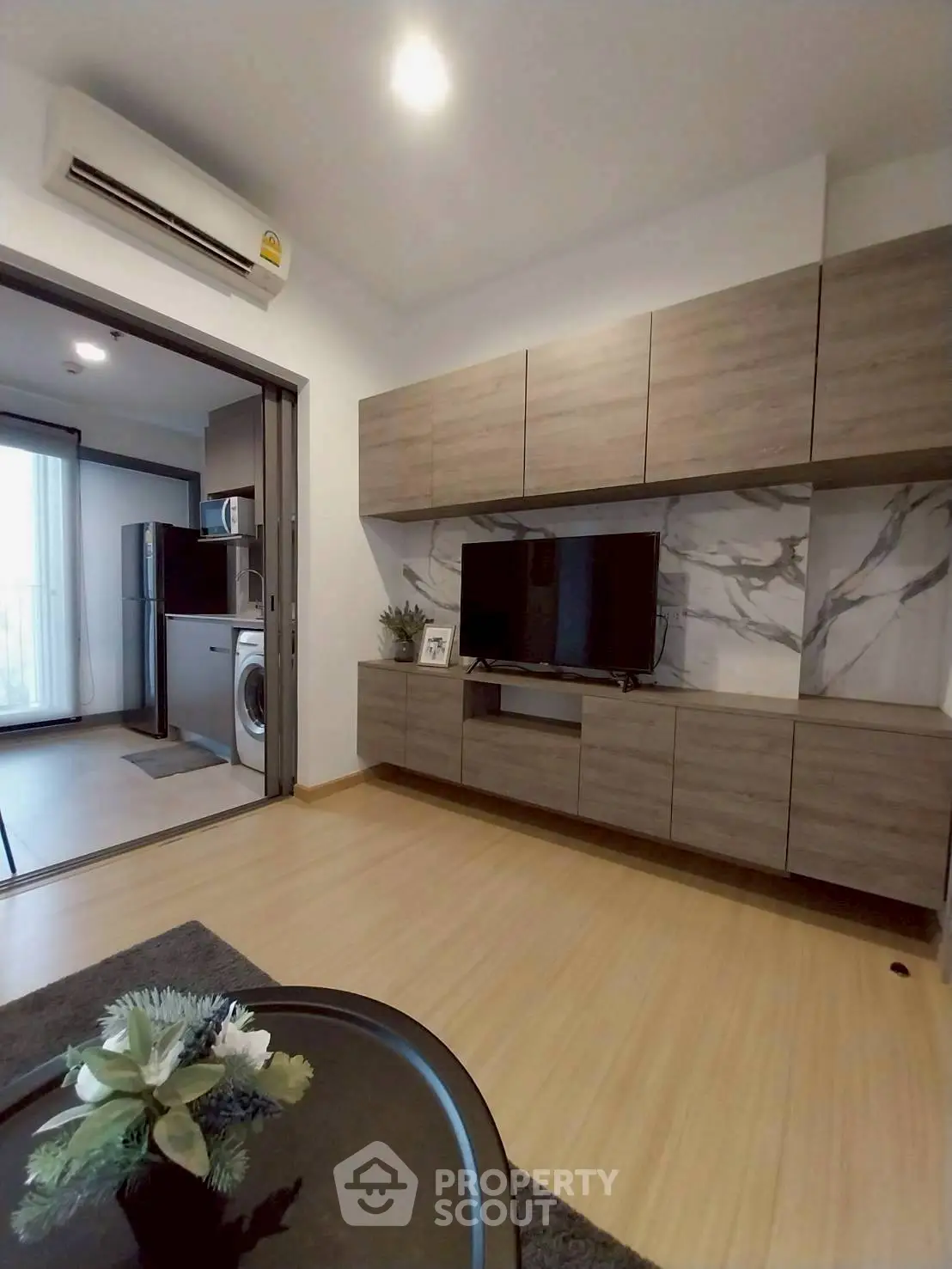 Modern living room with stylish cabinetry and open kitchen layout in a contemporary apartment.