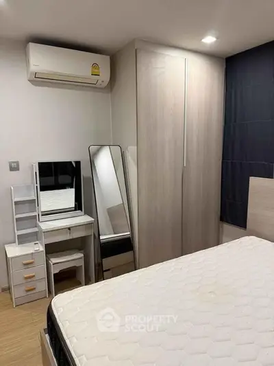 Modern bedroom with sleek wardrobe and air conditioning in a stylish apartment.