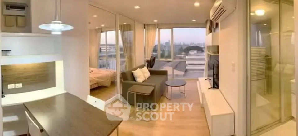 Modern open-plan apartment with city view, featuring cozy living area and stylish bedroom.