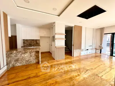 Spacious open-plan living area with modern kitchen and wooden flooring