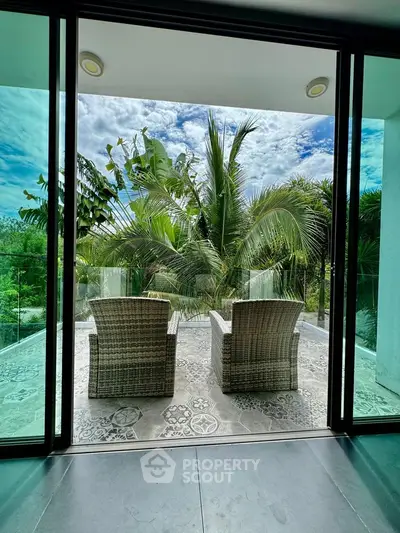 Luxurious balcony with tropical garden view and stylish wicker chairs