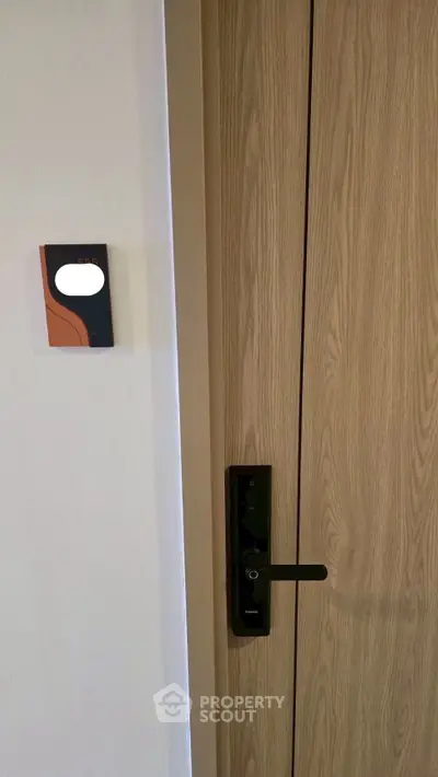 Modern wooden door with sleek electronic lock in contemporary apartment