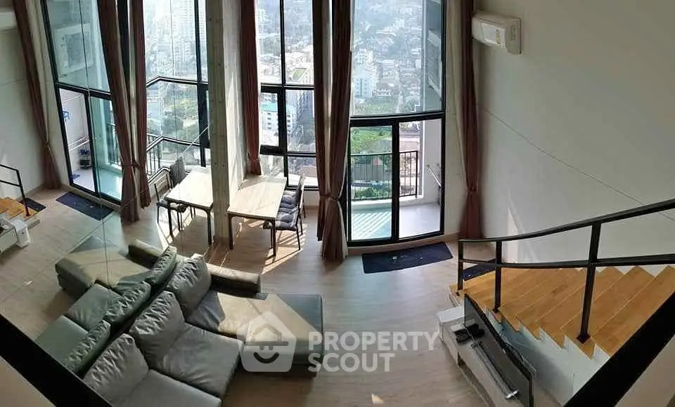 Luxurious modern living room with panoramic city views and stylish furniture.