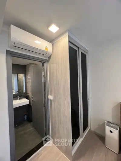 Modern bathroom with sleek design and air conditioning unit, featuring a stylish sink and mirror.
