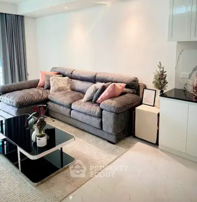 Modern living room with plush gray sofa, stylish coffee table, and elegant decor accents.
