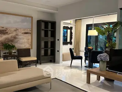 Stylish living room with modern decor and open layout, featuring elegant furniture and large artwork.