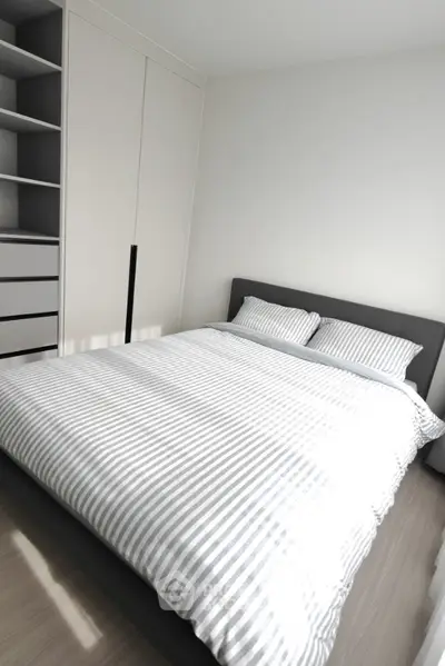 Modern bedroom with stylish bed and built-in wardrobe in a bright apartment.
