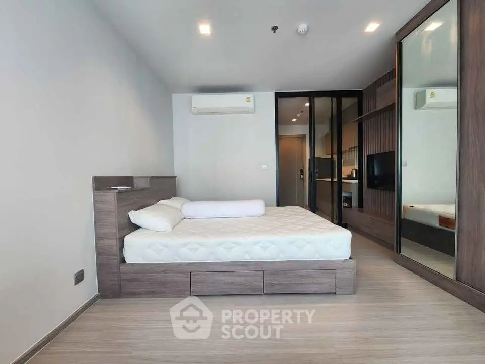 Modern bedroom with sleek design, featuring a comfortable bed and mirrored wardrobe in a stylish apartment.