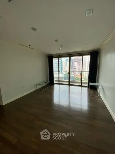 Spacious empty living room with large windows and city view
