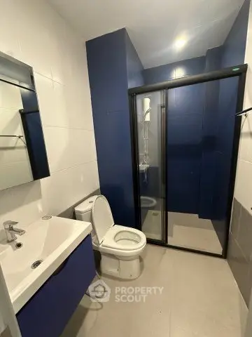 Modern bathroom with sleek blue accents and glass shower enclosure