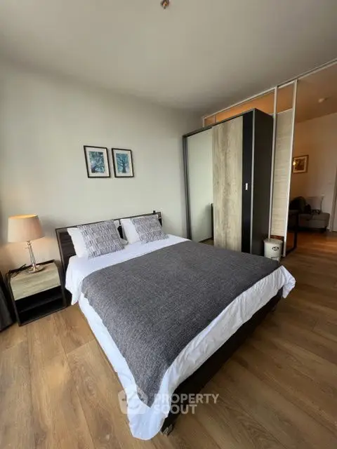 Modern bedroom with stylish decor and wooden flooring in a cozy apartment.