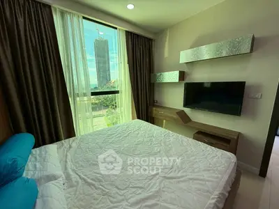 Modern bedroom with large window and city view, featuring sleek furniture and wall-mounted TV.