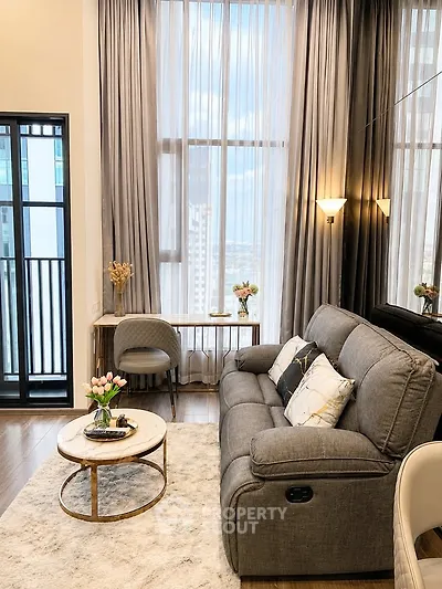 Luxurious living room with elegant decor and floor-to-ceiling windows offering stunning city views.