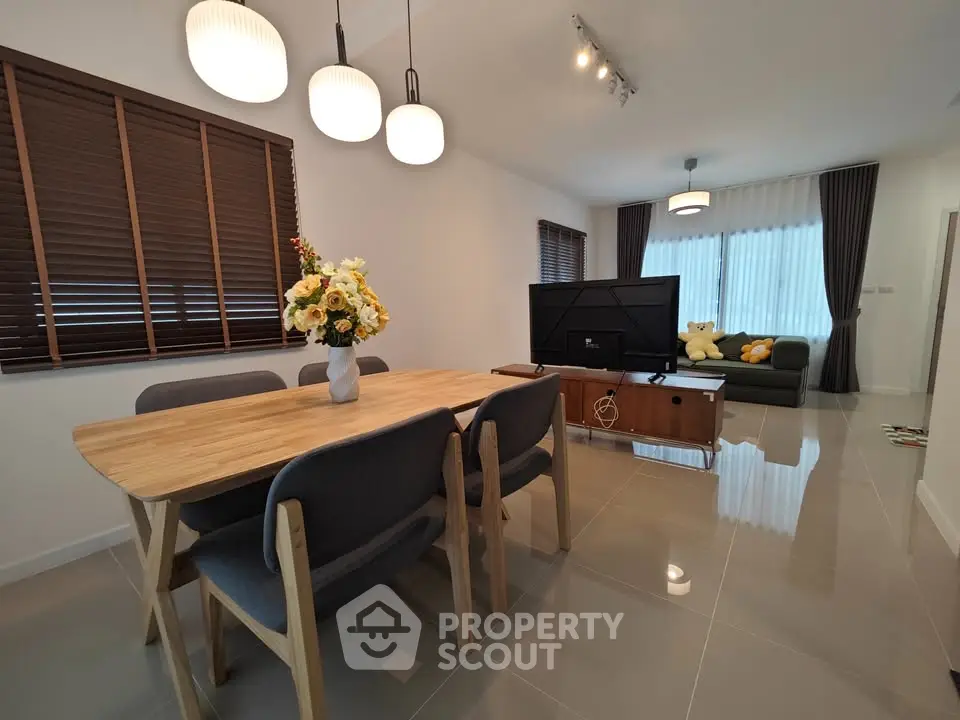 Modern living room with dining area, stylish furniture, and elegant lighting.