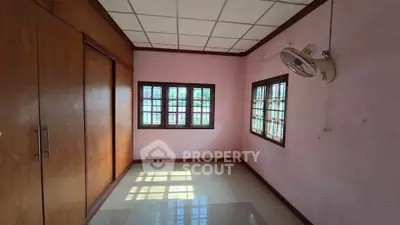 Spacious room with large windows and wooden accents, perfect for customization.