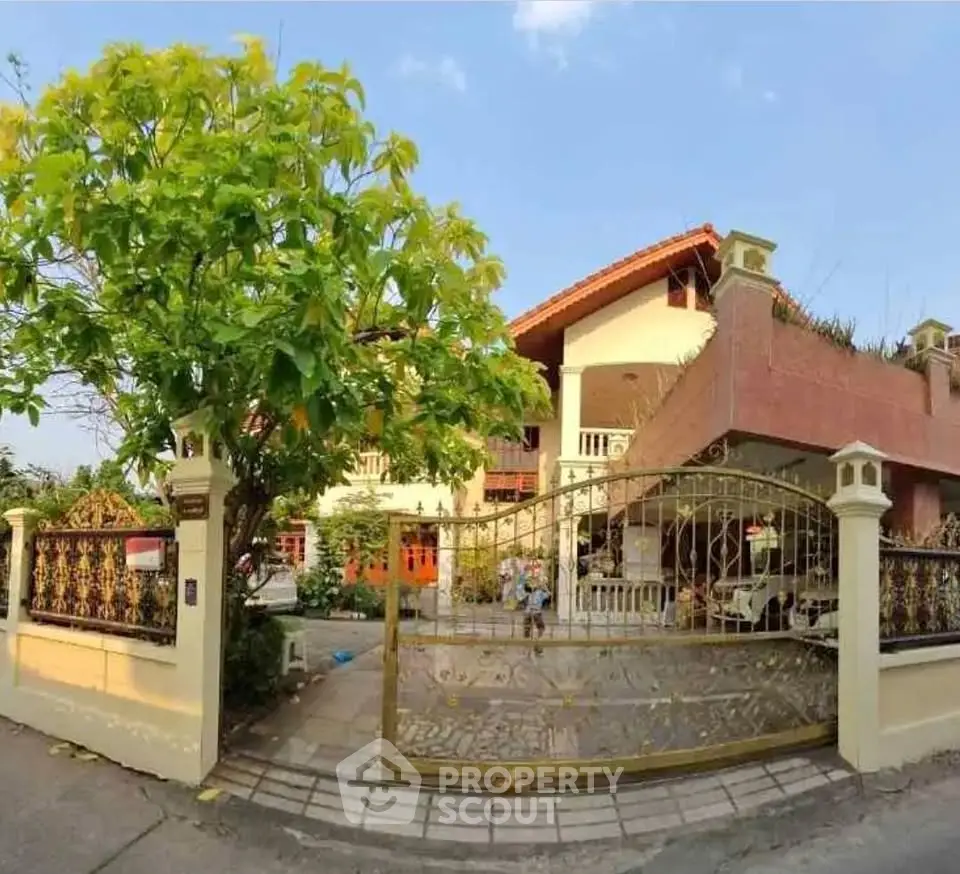 Charming two-story house with lush garden and gated entrance, perfect for family living.