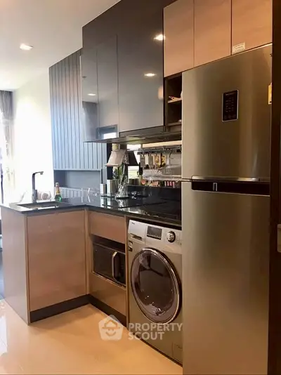 Modern kitchen with sleek appliances and stylish cabinetry in a contemporary apartment.