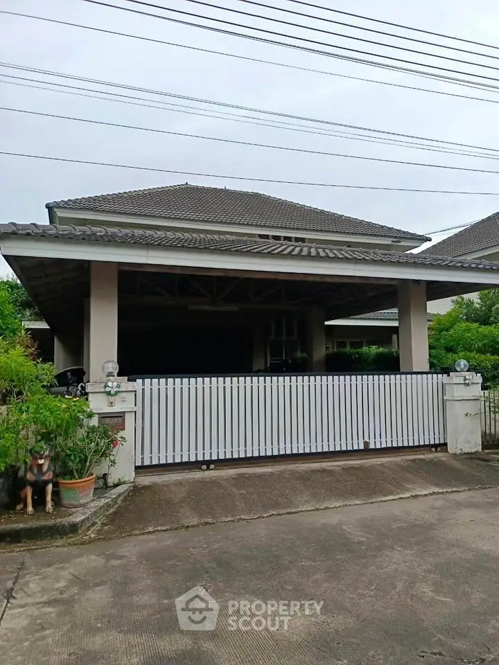 Charming single-story house with a spacious driveway and lush greenery, perfect for family living.