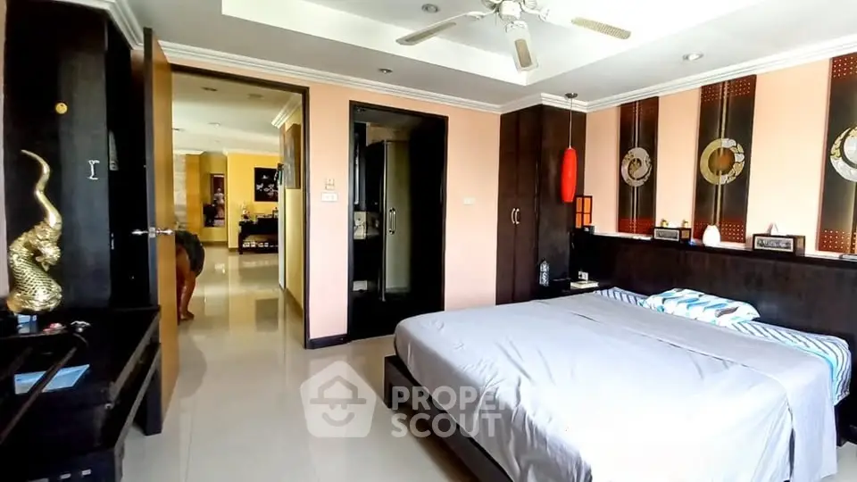 Spacious bedroom with modern decor and ceiling fan in a stylish apartment.