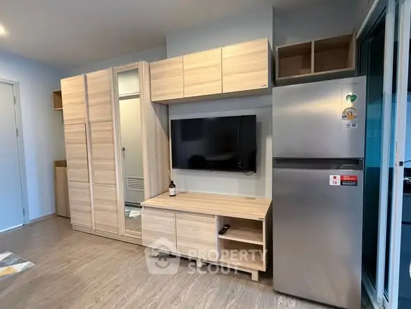 Modern living room with sleek wooden furniture and stainless steel fridge