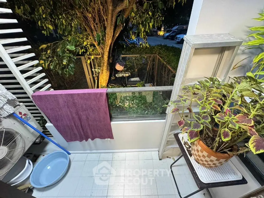Charming balcony with lush greenery and cozy ambiance, perfect for relaxation.