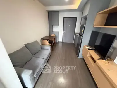 Modern living room with sleek furniture and open kitchen layout in a stylish apartment.