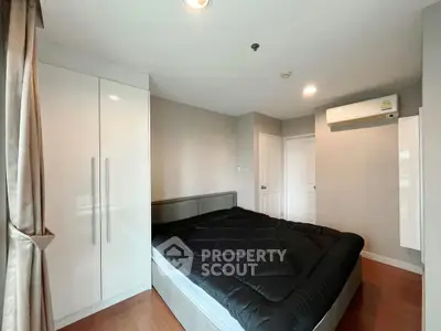 Modern bedroom with sleek design, featuring a comfortable bed, built-in wardrobe, and air conditioning.