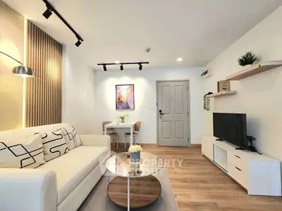 Modern living room with stylish decor and cozy ambiance, featuring a comfortable sofa and sleek entertainment unit.