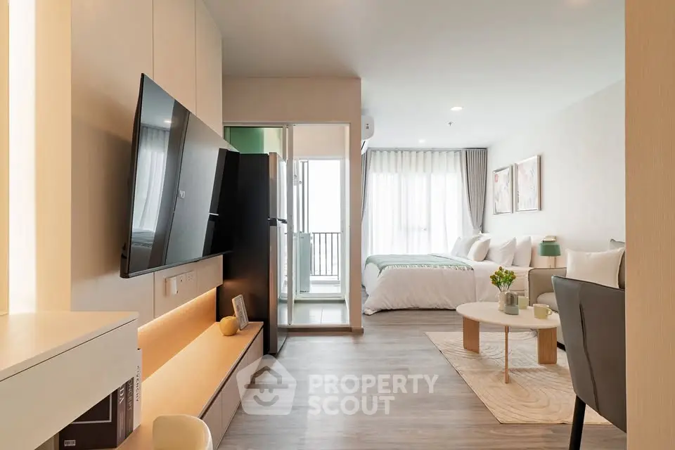 Modern open-plan living room with sleek TV and cozy bedroom view