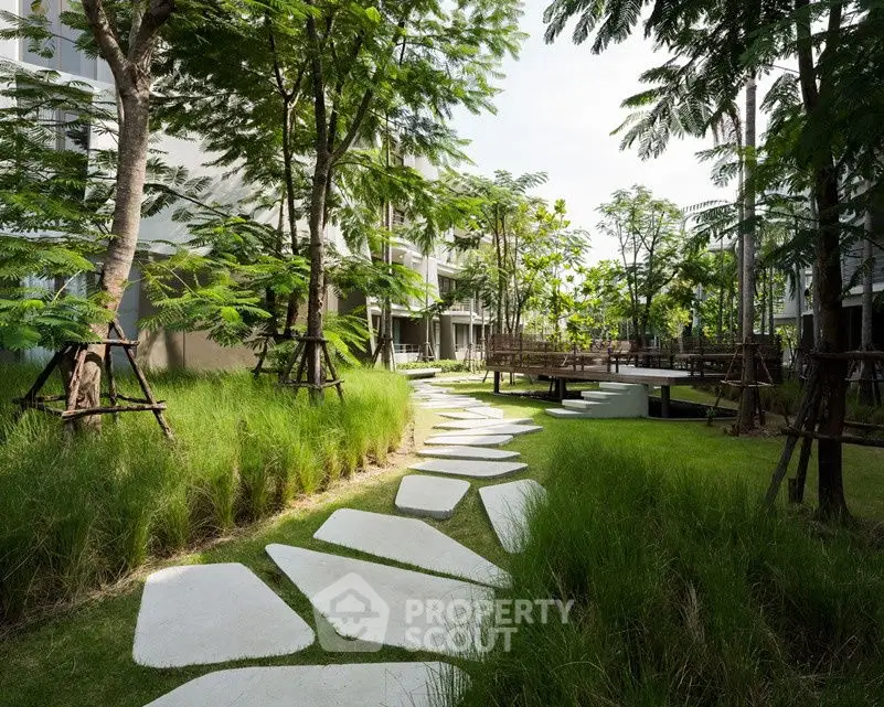 Lush garden pathway with modern landscaping in upscale residential complex.