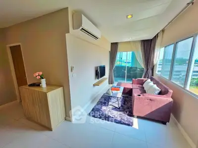 Modern living room with large windows, stylish sofa, and balcony access in a bright apartment.