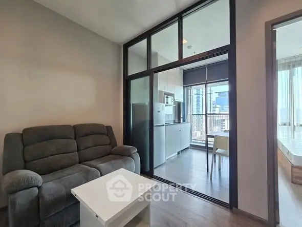 Modern apartment interior with cozy living room and sleek kitchen, featuring large windows and natural light.