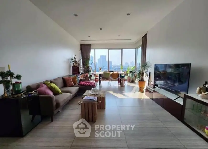 Spacious living room with city view, modern decor, and large windows for natural light.