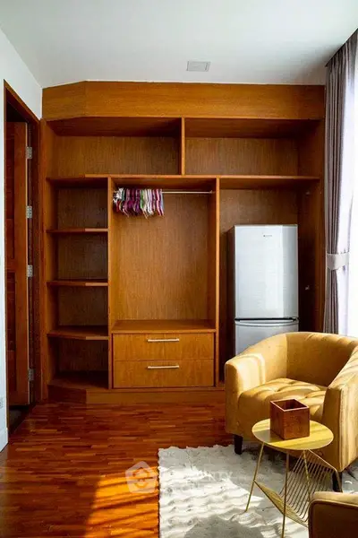 Cozy living room with wooden shelves and modern fridge, perfect for stylish urban living.