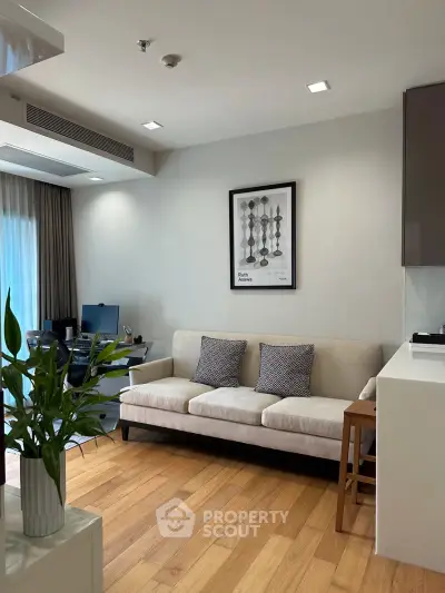 Modern living room with stylish decor and natural light, featuring a comfortable sofa and wooden flooring.