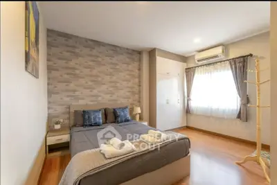 Spacious bedroom with modern decor and natural light in a stylish apartment.