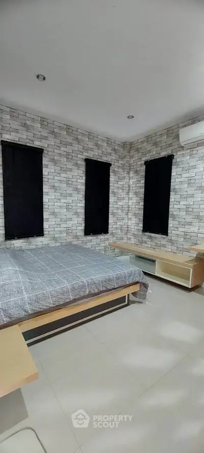 Modern bedroom with stylish brick accent wall and sleek furniture