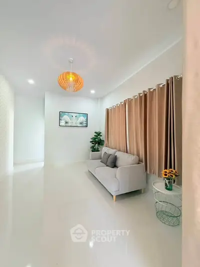 Elegant living room with modern decor, featuring a cozy sofa, stylish lighting, and large windows with curtains.