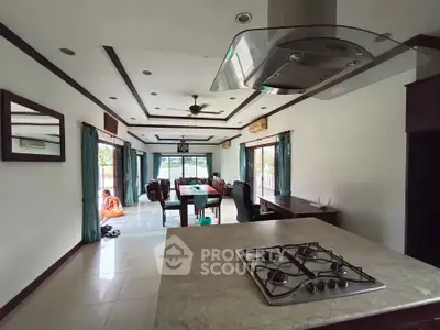 Spacious open-layout kitchen and living room with gas stove and dining area.