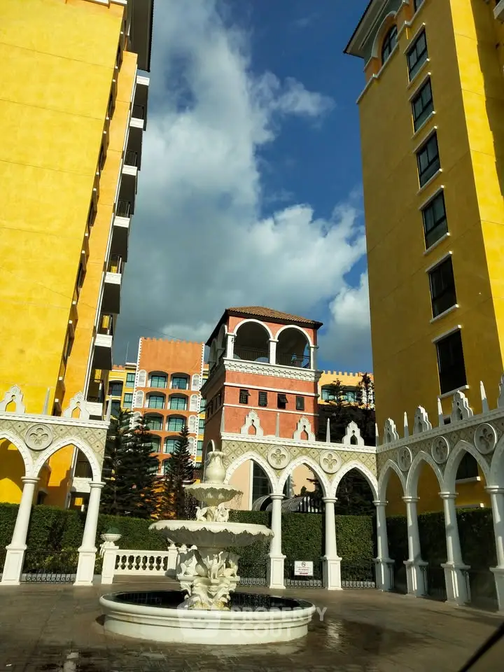 Stunning architectural exterior with vibrant colors and elegant fountain centerpiece.